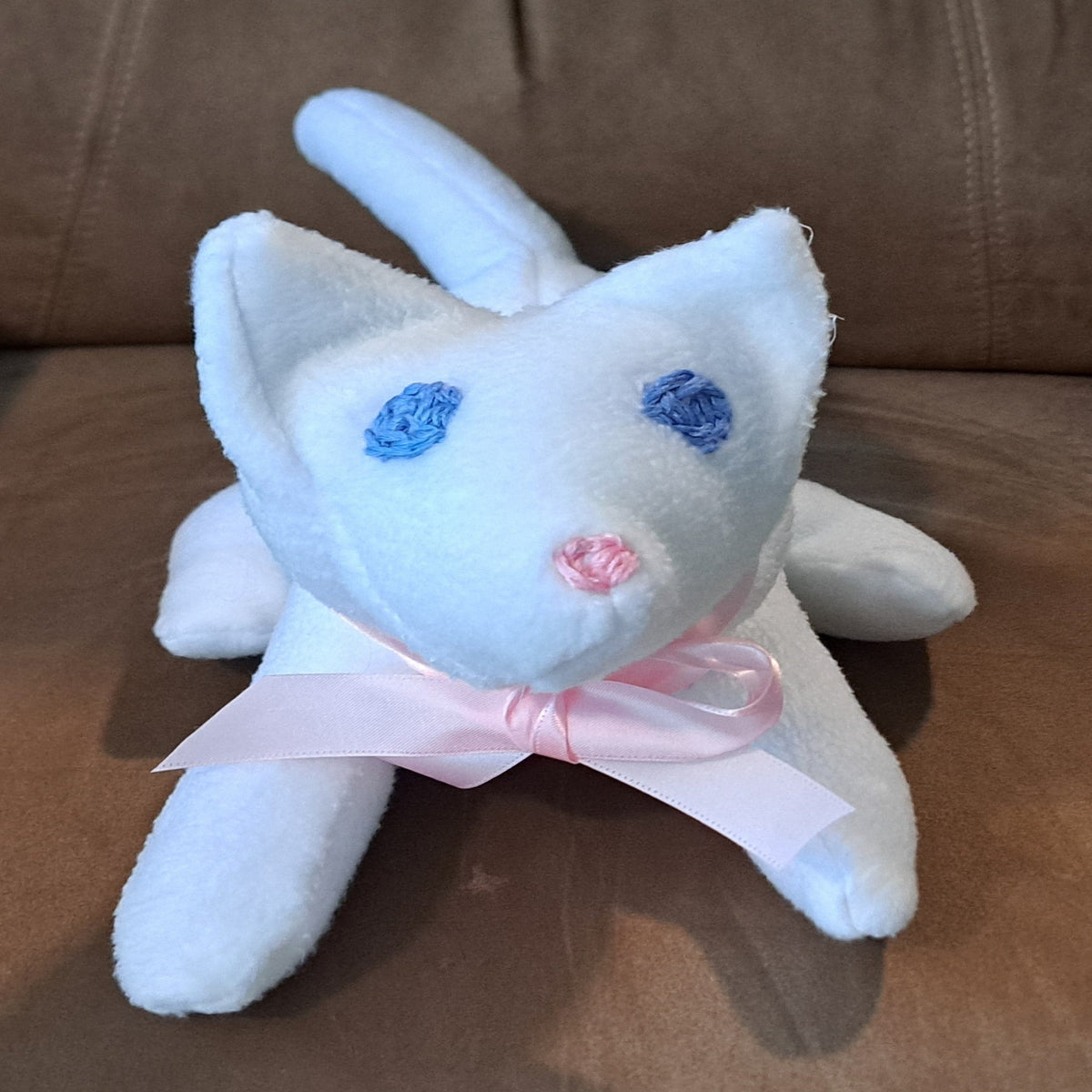 White fleece kitten with blue embroidered eyes abd a pink embroidered nose, 12"long x 7" tall, safe for all ages