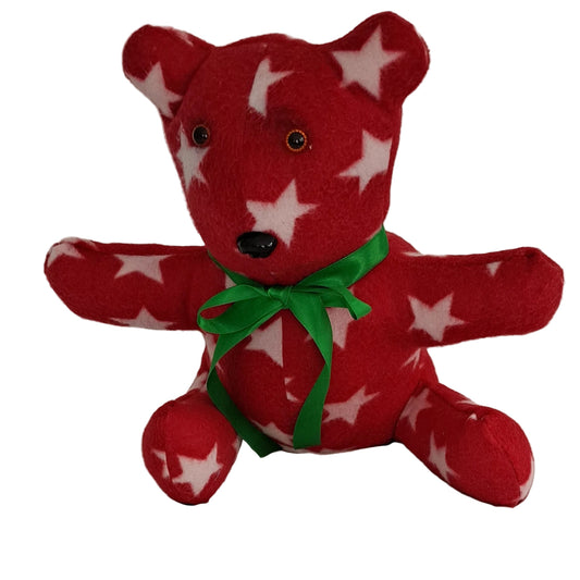 A red fleece sitting teddy bear with white star patterns, with arms outstretched 17 'wearing a bright green ribbon bow around its neck. ready for Christmas change to a blue bow for 4th of Jul, plastic eyes & nose, ages 3+ years
